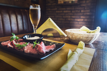 Salami and rocket salad in an Italian restaurant served with a cold beer on a wooden table with paper placematsの写真素材