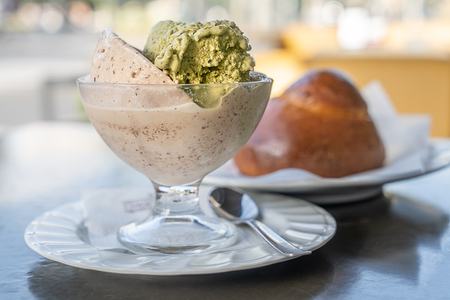 Toasted almond granita and pistachio. Sweet cold spoon, typical of Sicilian cuisine. It is a semi-frozen liquid compound prepared with water, sugar and fruit or other ingredientの写真素材