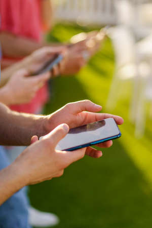 Vertical shot of people using smartphone. Closeup on the hands typing on the cell phone screen.の写真素材