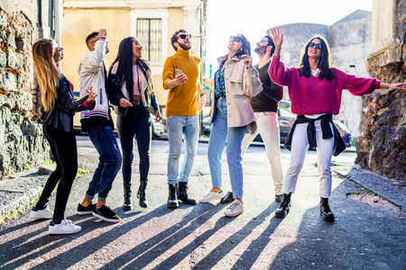 Young people having fun smiling and dancing together in the street. Youth celebrating freedom and multiracial togetherness union concept.の写真素材