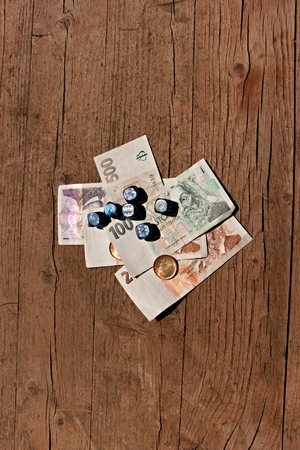 Wooden table on which are placed the dice on a few paper bills