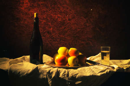 A bottle of wine with four apples and a glass.の写真素材