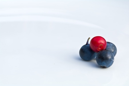Cranberry and blue berries on a white plateの写真素材