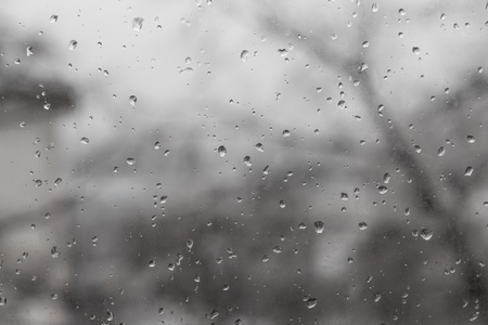Raindrops on glass in rainy weather grayの写真素材