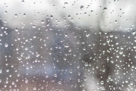 Raindrops on glass, wet city window, rain in the city outside the windowの写真素材