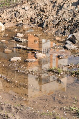 Reflection of high-rise buildings in a dirty puddleの写真素材