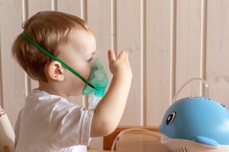 Little boy makes inhalation with a nebulizerの写真素材