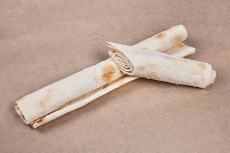 Thin pita bread rolled up on baking paper. Lavash.の写真素材