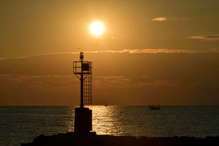 Fishing boat back to the harbor at the sunriseの写真素材