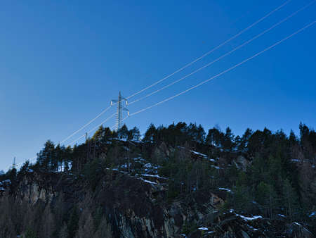 Picture of a power line taken on the Alps close to a dam.の写真素材