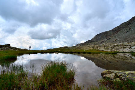 Picture of tourist hiking close to one of the lakes in Campagneda meadowの写真素材