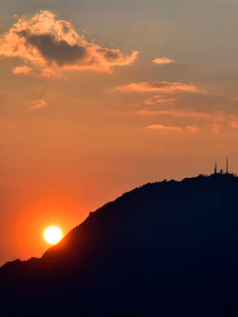 The sunset crete the illusion of the sun rolling from the Valtellina mountainsの写真素材