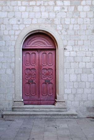 Red door on a stone churchの写真素材