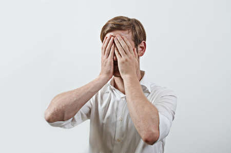 Man Covers His Face by Hand
