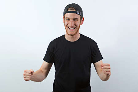 Joyful, Very Happy Smiling Young Adult Male in Dark T-Shirt and Baseball Hat Worn Backwardsの写真素材