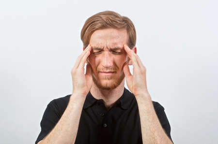 Headache. Young Adult Male in Black T-Shirt in Pain Touches His Head, Eyes Closed