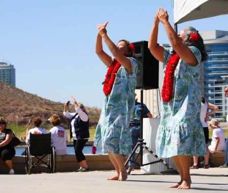 Two women dance to Hawiian music, wearing print dresses and lei, during the Dragon Boat Festival at Tempe Town Lake 2012 のeditorial素材