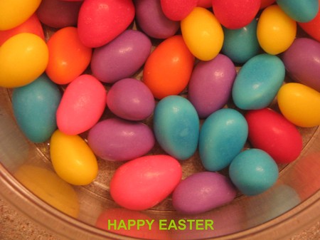 A bowl of easter egg candies with "happy Easter" textの写真素材