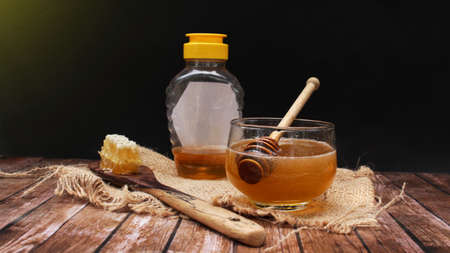 Honey is nutritious for health, stirring with a honey spoon and honeycombの写真素材