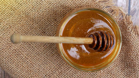 Honey is nutritious for health, stirring with a honey spoon and honeycombの写真素材