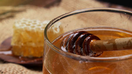 Honey is nutritious for health, stirring with a honey spoon and honeycombの写真素材