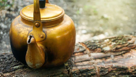 A teapot filled with water, colored gold and with flare and highlightの写真素材