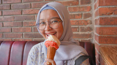 Asian hijab girl while enjoying gelato ice cream