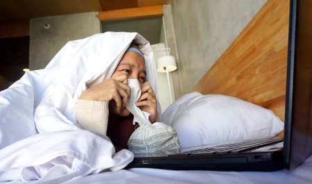 Asian girl crying watching a movie on a laptopの写真素材