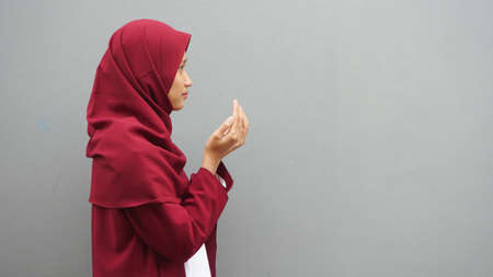 Asian muslim woman prays to God, praying gesture hands raised up, Islam religion spiritual life