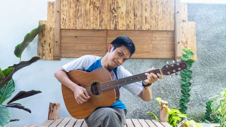 a man playing guitar in parkの写真素材