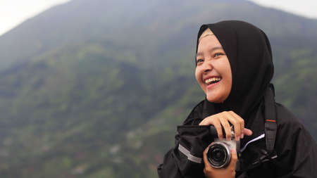 The woman wearing the hijab vacation at Spot New Selo with the background of Mount Merbabuの写真素材