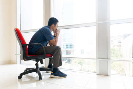 business man sitting on red chair in officeの写真素材
