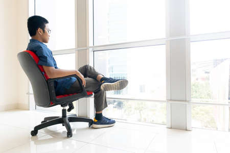 business man sitting on red chair in officeの写真素材