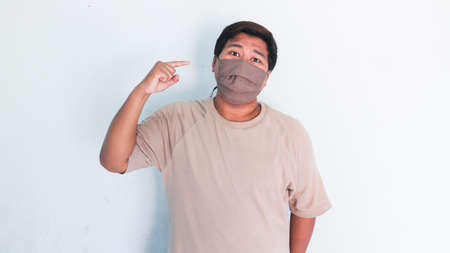 Portrait of a asian fat man in a medical mask show stop hand gestureの写真素材