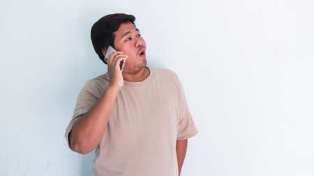 ASIAN FAT MAN IS CALLING A FRIENDの写真素材