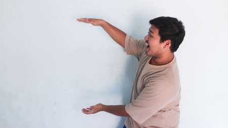 Asian fat man pointed somethingの写真素材