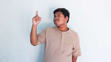ASIAN FAT MAN WHO ARE THINKING OF SOMETHING AND GET IDEASの写真素材