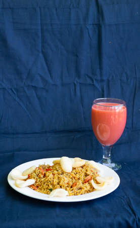 Nasi Goreng or fried rice with sausage and crackers combine guava juiceの写真素材