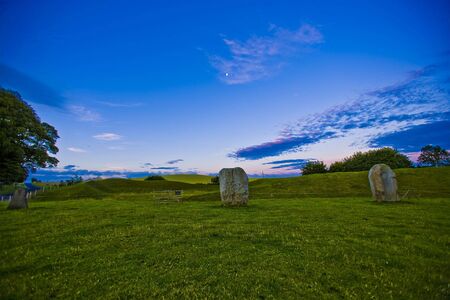 Sunrise with full moon over Avebury stones in Wiltshireの写真素材