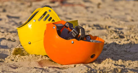 Two colourful helmets in the sand