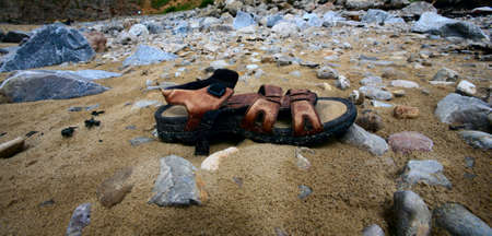 Washed up Sandel on beachの写真素材