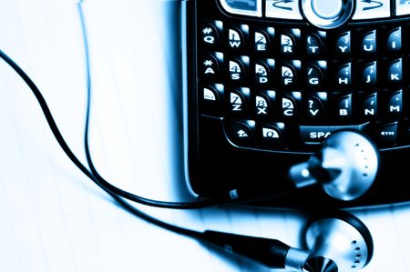 Mobile phone with head phones in blue toneの写真素材