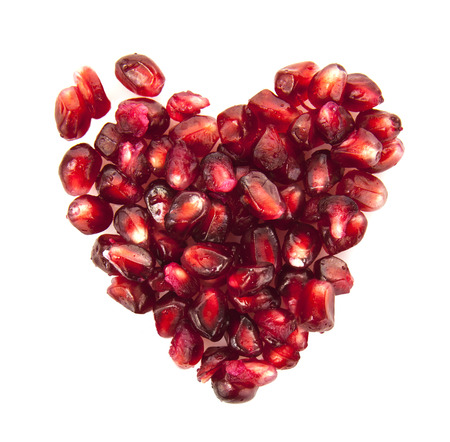 Heart of pomegranate seeds on white backgroundの写真素材