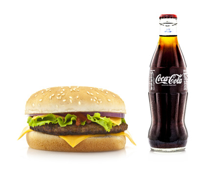 SWINDON, UK - MARCH 28, 2014: Big hamburger with a bottle of Cold Coca-Cola on a white backgroundのeditorial素材