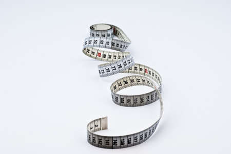 bundled up white measuring tape on a white backgroundの写真素材