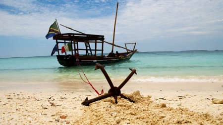 A fishing boat anchored by the beach in Zanzibarの写真素材