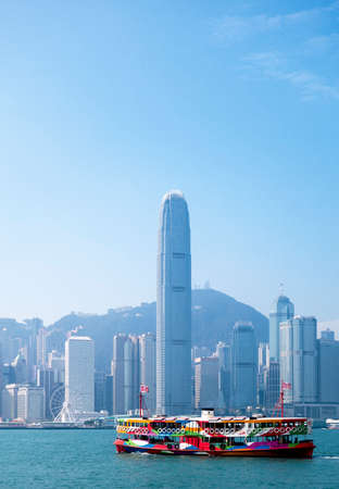 A ferry in Hong Kong harbour with the city skyline in the backgroundの写真素材