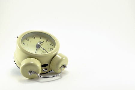 Beige alarm clock, stylized antique with black arrows.の写真素材