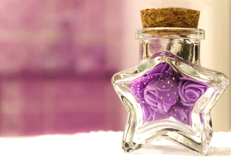 Transparent vessel in the form of a star with purple flowers.