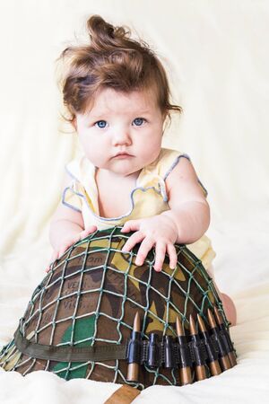 Beautiful little kid with a military helmet.の写真素材